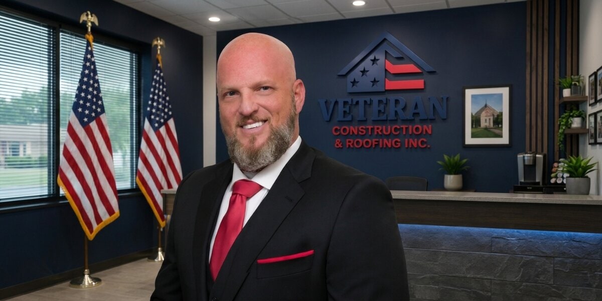 Leo Dailey in the Veteran Construction & Roofing office with company logo and American flags.