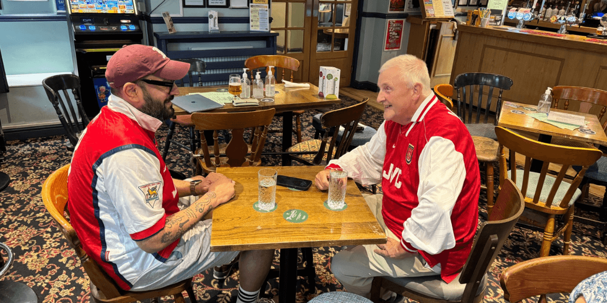 Jay Shah speaking with another person across a table in a pub.