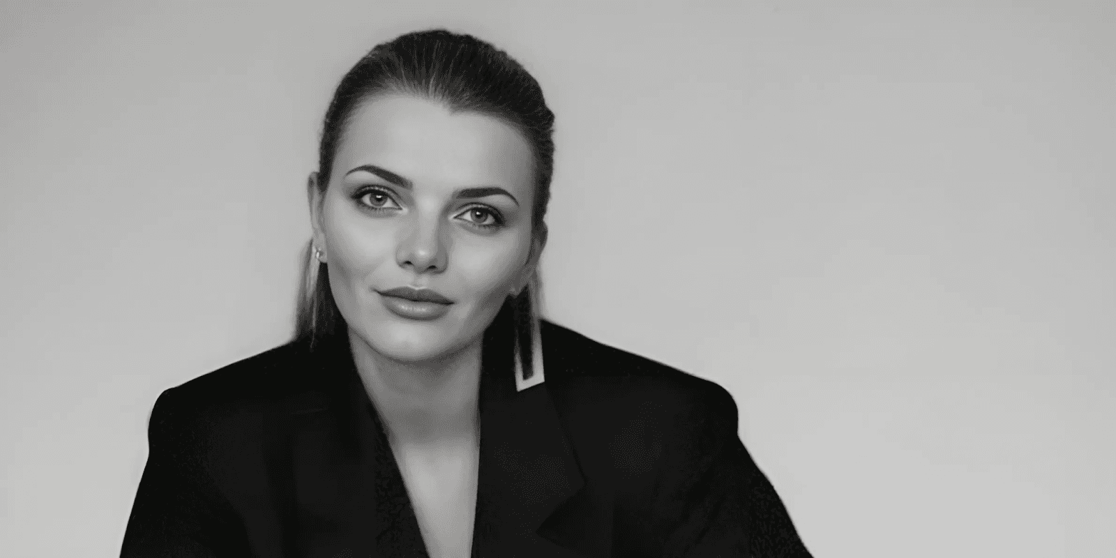 Sam Mishra, founder of The Medical Massage Lady, poses confidently in a black blazer against a plain background.