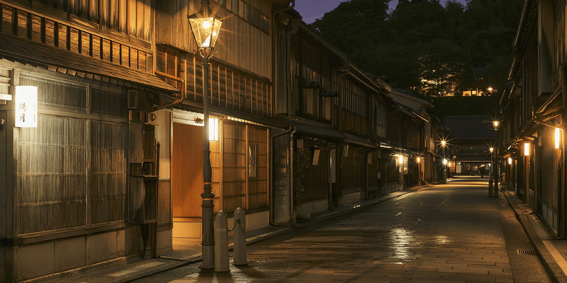 Lantern-lit street lined with traditional wooden buildings at night in Ishikawa, Japan.