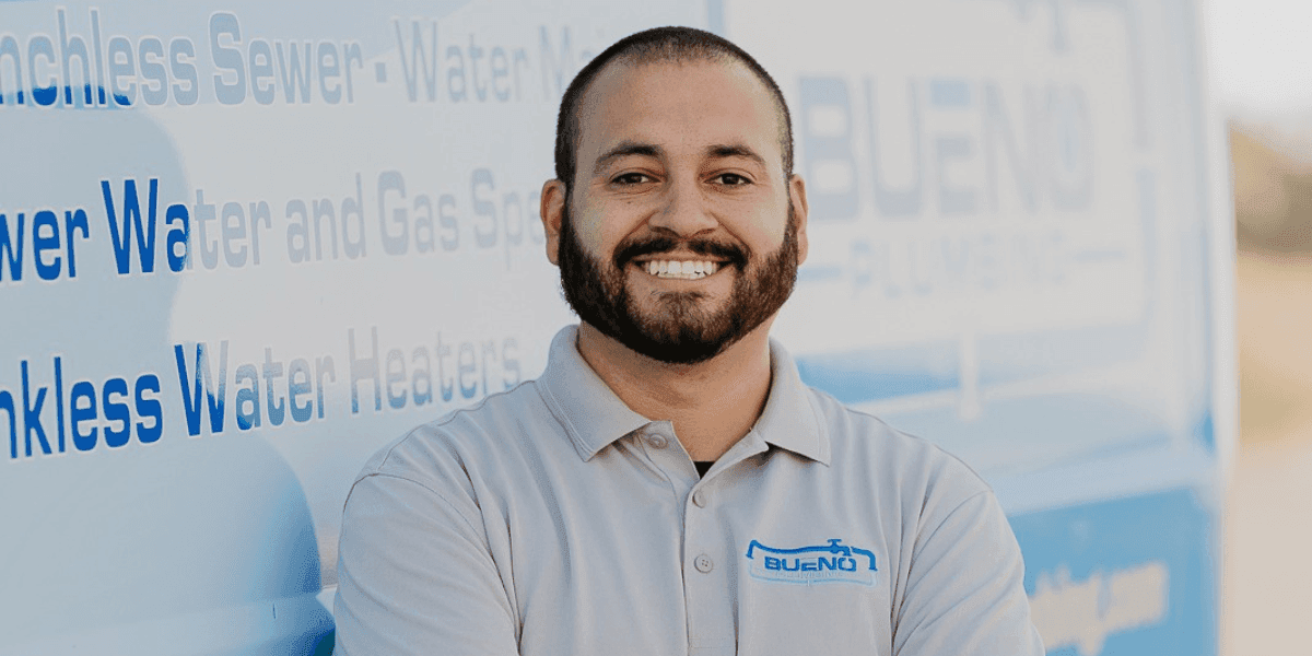 Kevin Bueno of Bueno Plumbing and Rooter standing in front of a company service vehicle.