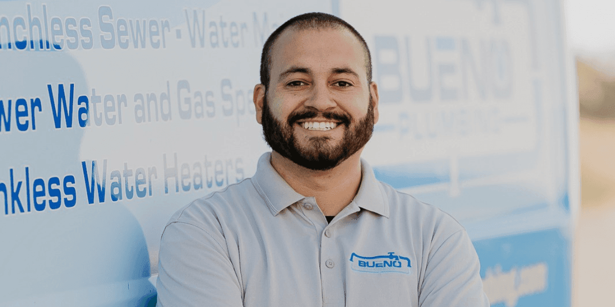 Kevin Bueno of Bueno Plumbing and Rooter standing in front of a company service vehicle.