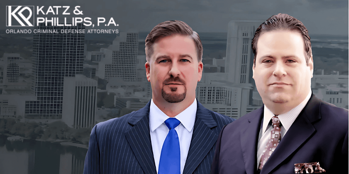 Two suited men in front of a city skyline with the Katz & Phillips, P.A. logo above them.