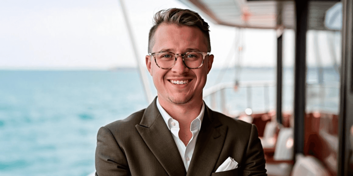 Dr. Connor Robertson smiling on a yacht, representing focused marketing strategy for scalable business growth.