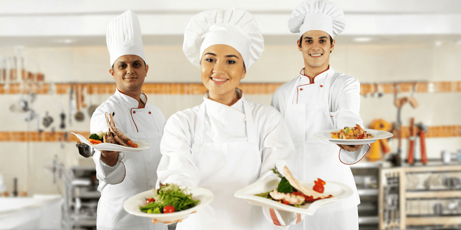 Three chefs proudly presenting dishes in a professional kitchen, symbolizing Hozpitality Group's expansion and commitment to the hospitality industry."