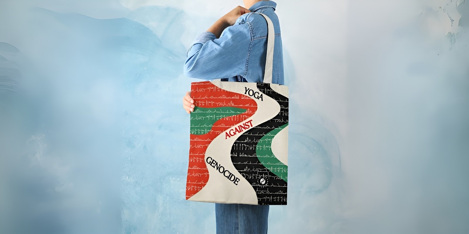 Person holding a tote bag with “Yoga Against Genocide” design in solidarity with Gaza humanitarian fundraiser.