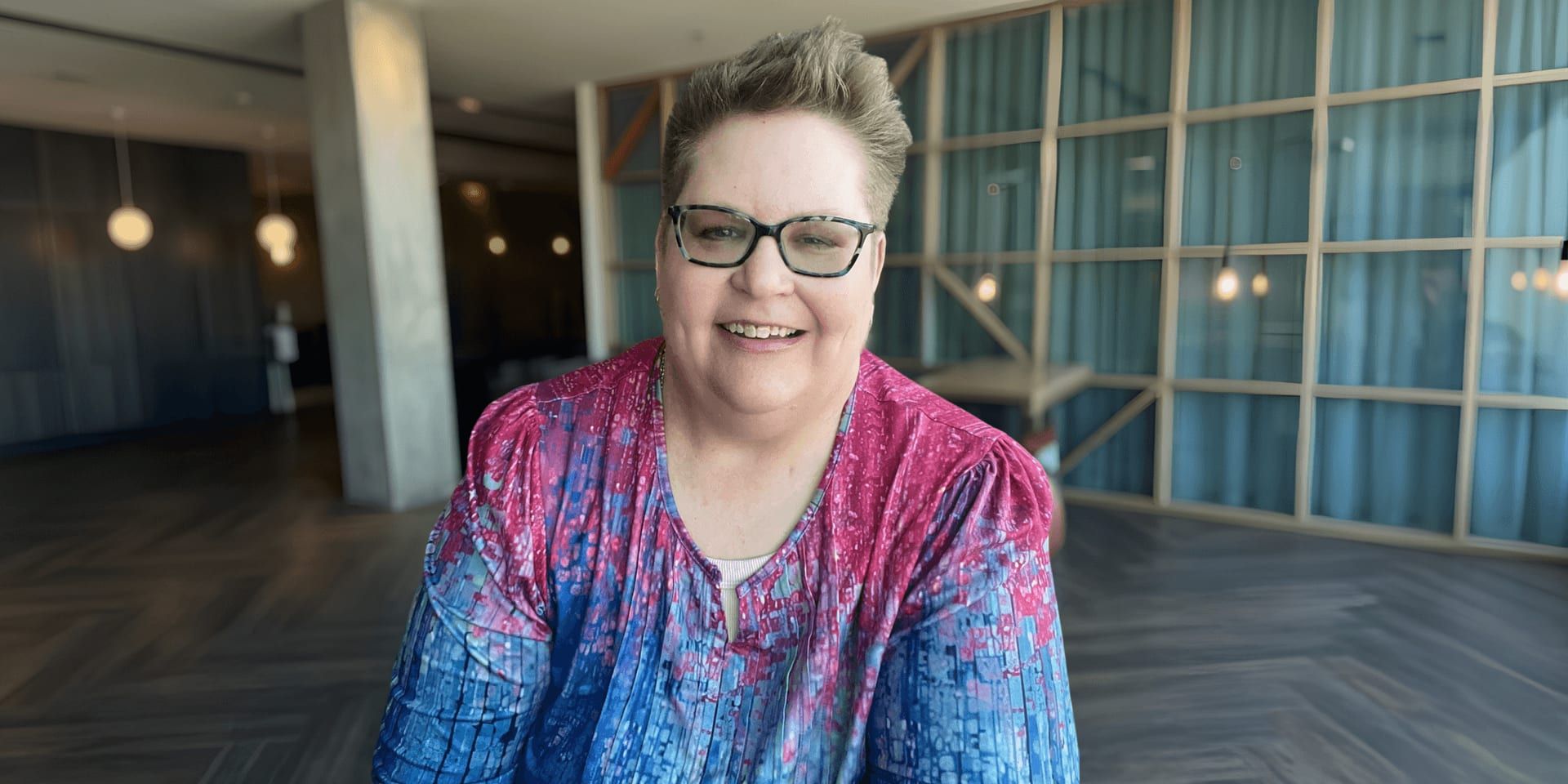 Mickey Forsyth in a contemporary workspace, representing self-care, resilience, and personal growth for high-capacity women.