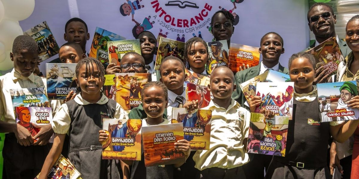 Group of Nigerian schoolchildren holding books from the Nigeria Heritage Series, promoting cross-cultural understanding and national unity.