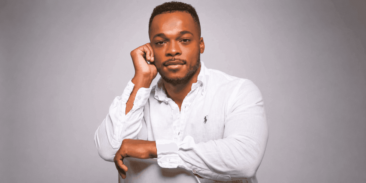 Portrait of author Troy Cannon wearing a white button-down shirt against a gray background.