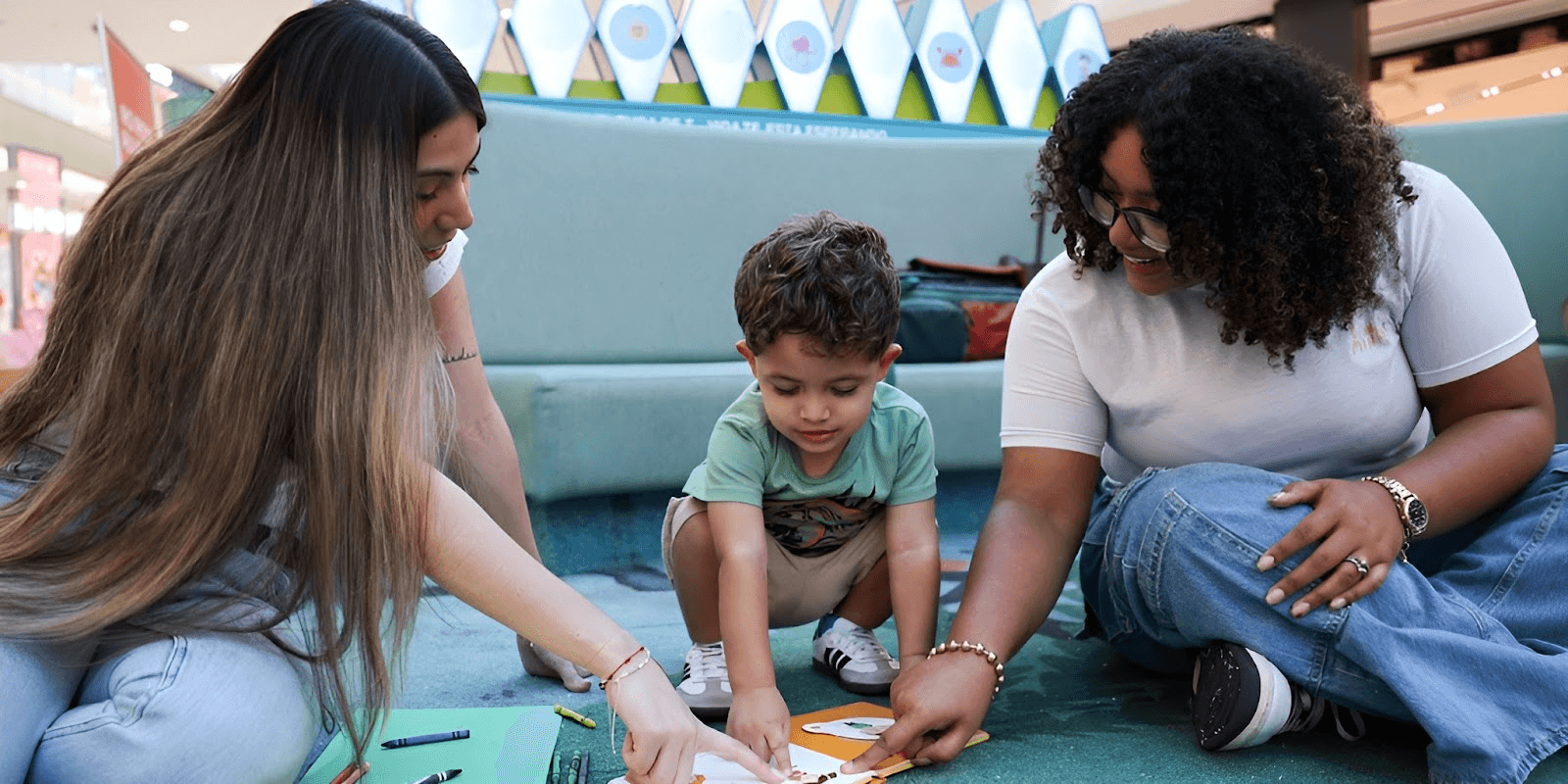A child enjoys creative time with two caregivers, highlighting MiNaNi PR's personalized childcare services in Puerto Rico.