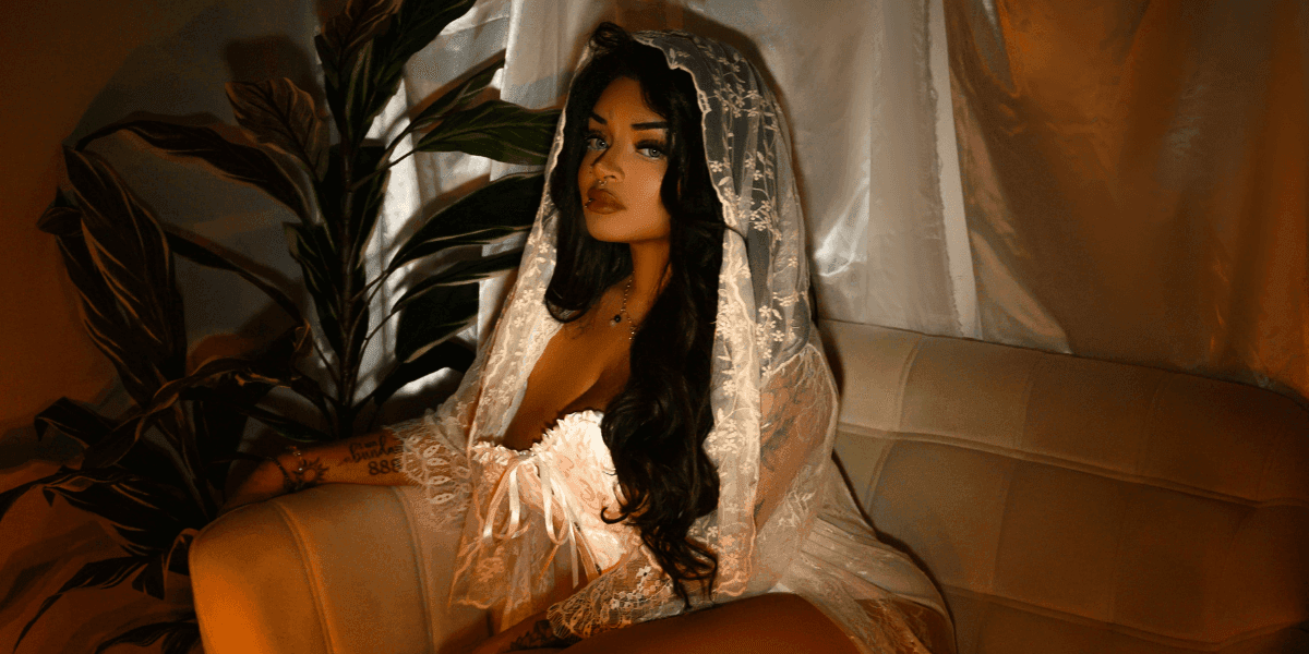 "Anastasia Artemiou seated in a soft, mystical setting, representing her spiritual brand The Manifestation Doll focused on magick, healing, and mindset work."