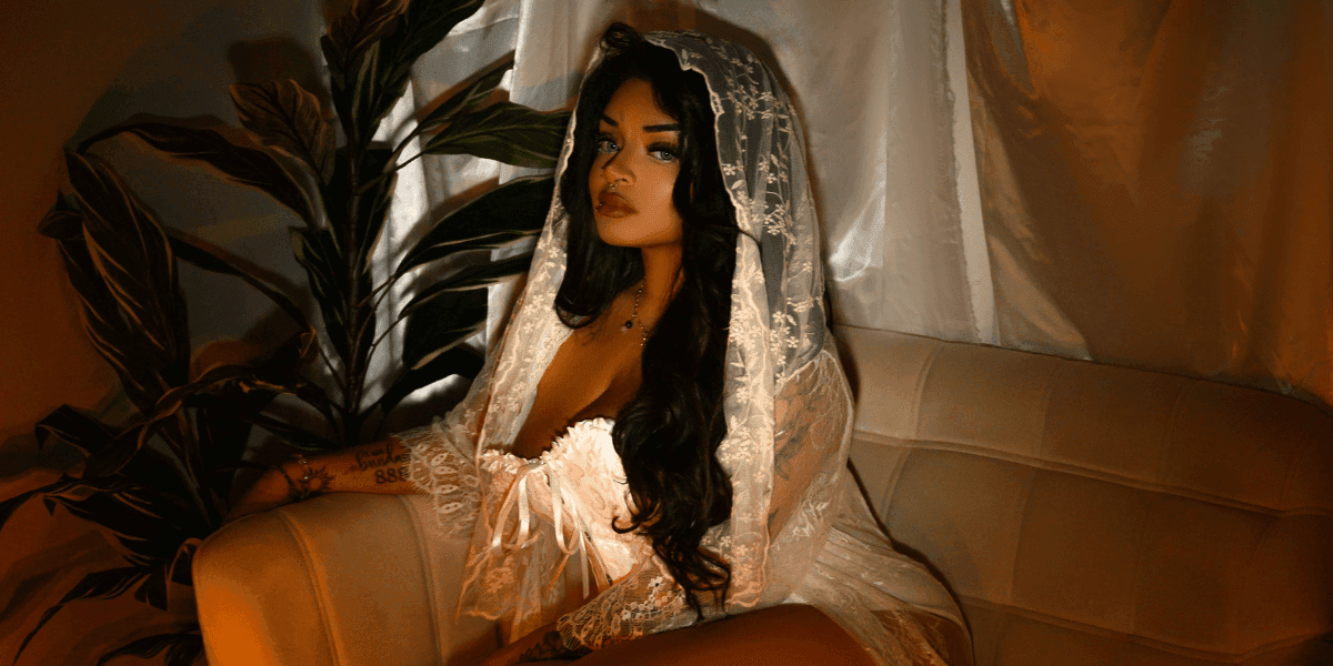 "Anastasia Artemiou seated in a soft, mystical setting, representing her spiritual brand The Manifestation Doll focused on magick, healing, and mindset work."