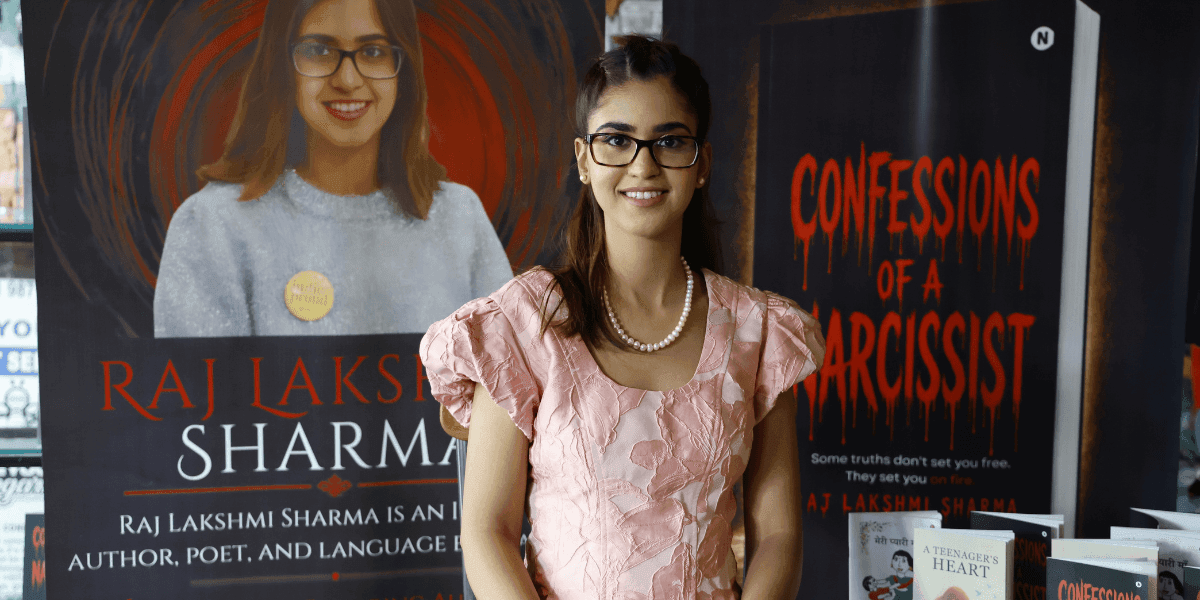 Raj Lakshmi Sharma stands beside promotional displays for Confessions of a Narcissist.