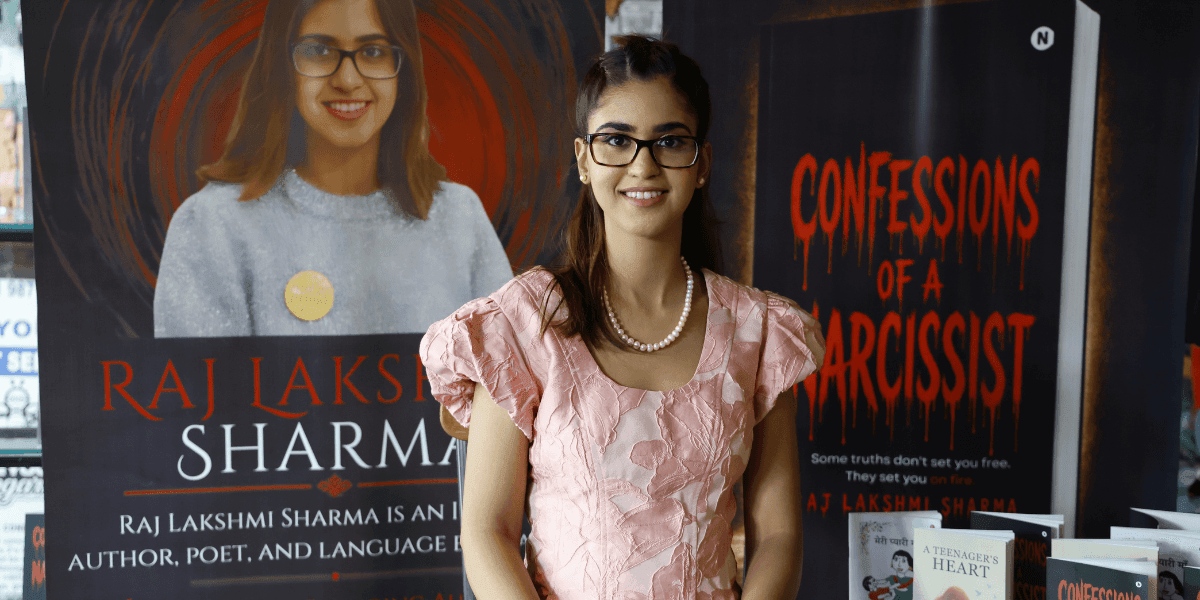 Raj Lakshmi Sharma stands beside promotional displays for Confessions of a Narcissist.