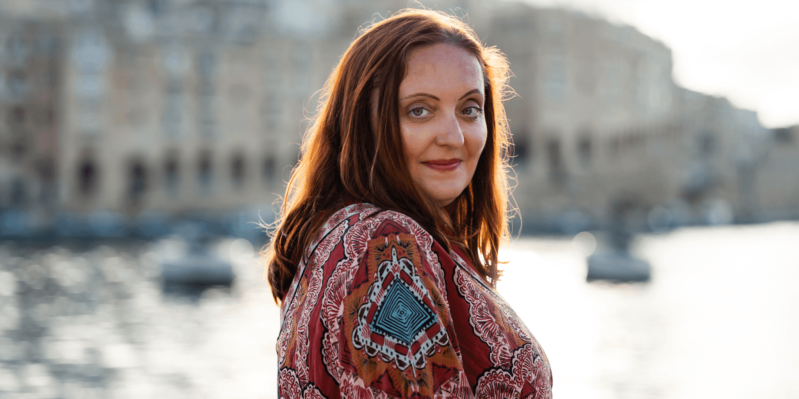 Inga Kastrone, founder of Healing Radiance, standing near water, embodying the essence of spiritual healing.