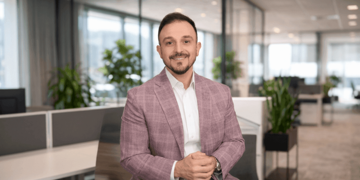 Adam Shoar, founder of DidYouKnow.Pro, seated in modern office promoting automotive finance training platform.