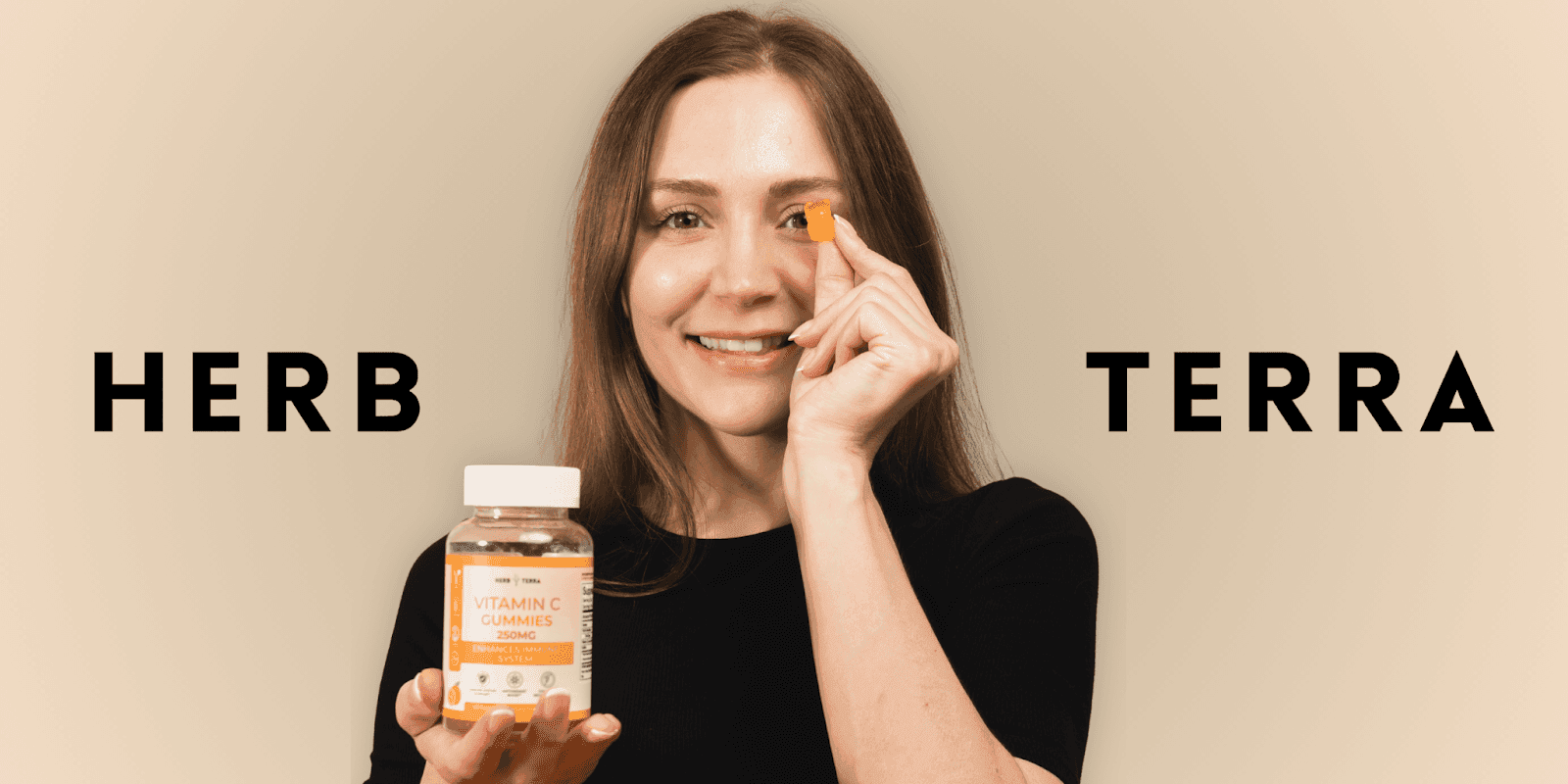 Smiling woman holding Herb Terra Vitamin C Gummies 250mg, showing one gummy for immune system support, antioxidant boost, and collagen regeneration