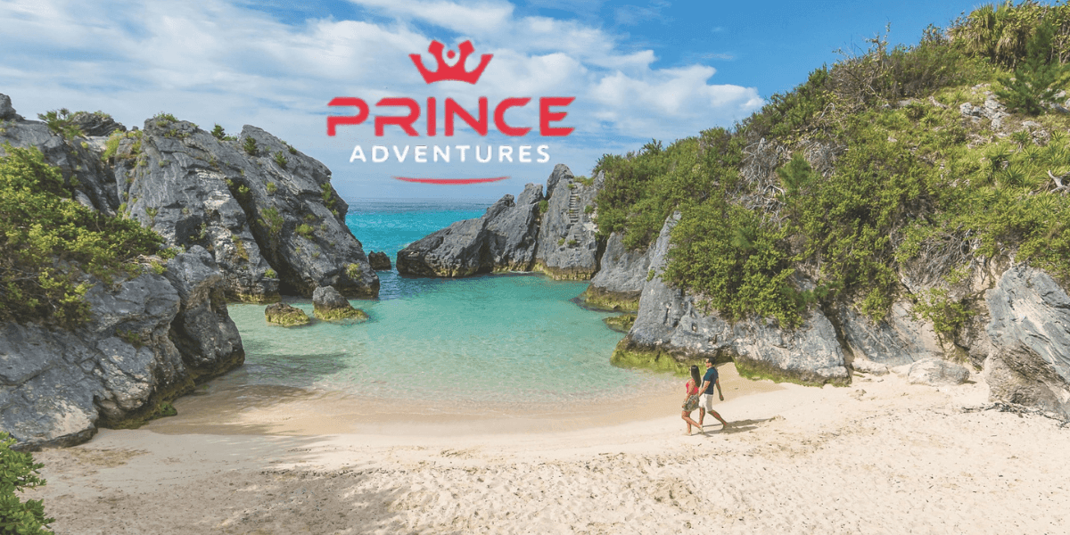 "Couple walking hand in hand along a secluded tropical beach with turquoise water, cliffs, and the Prince Adventures travel logo."