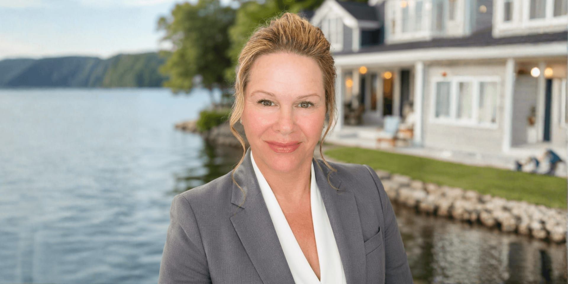 Romi Hancock, RE/MAX Creative Realty agent, posing in front of a waterfront home.