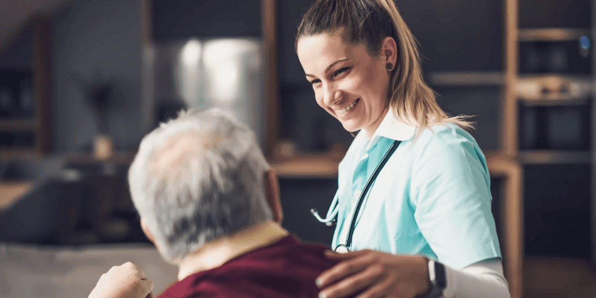Smiling healthcare worker supporting an older adult during home care, highlighting compassionate recovery and COPD management.