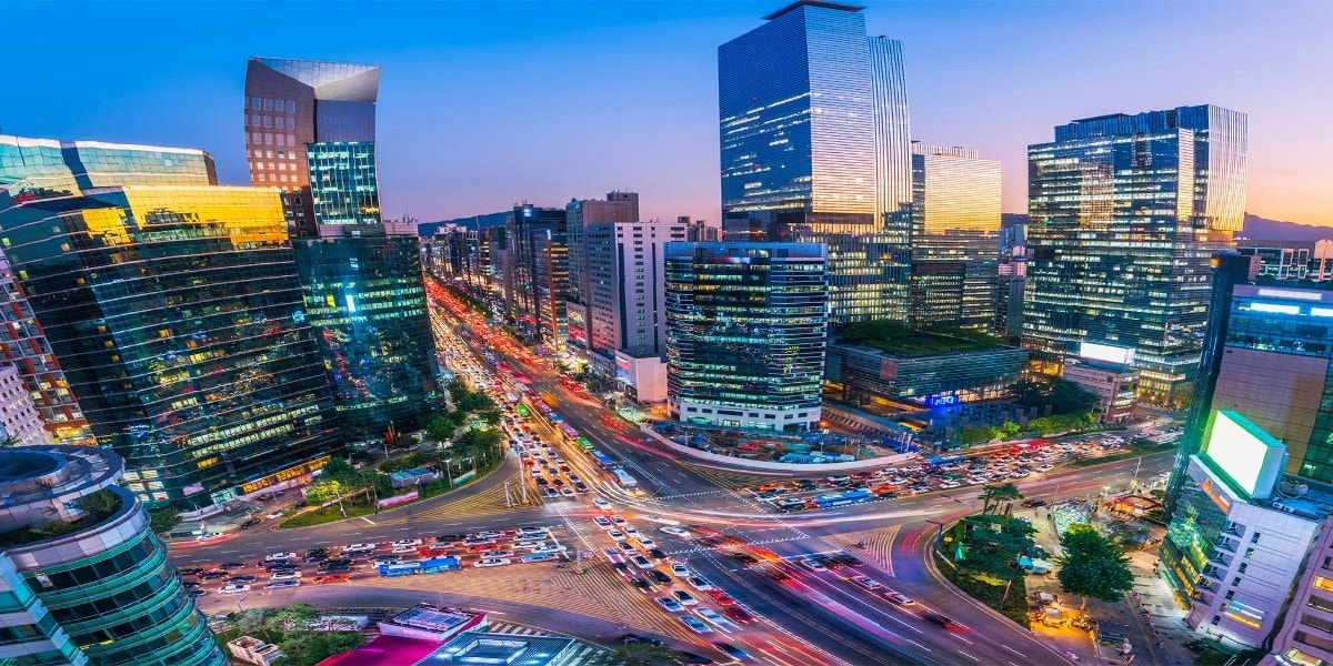 A bustling cityscape with modern skyscrapers and busy streets lit up at night, showcasing a vibrant urban atmosphere in a metropolitan area."