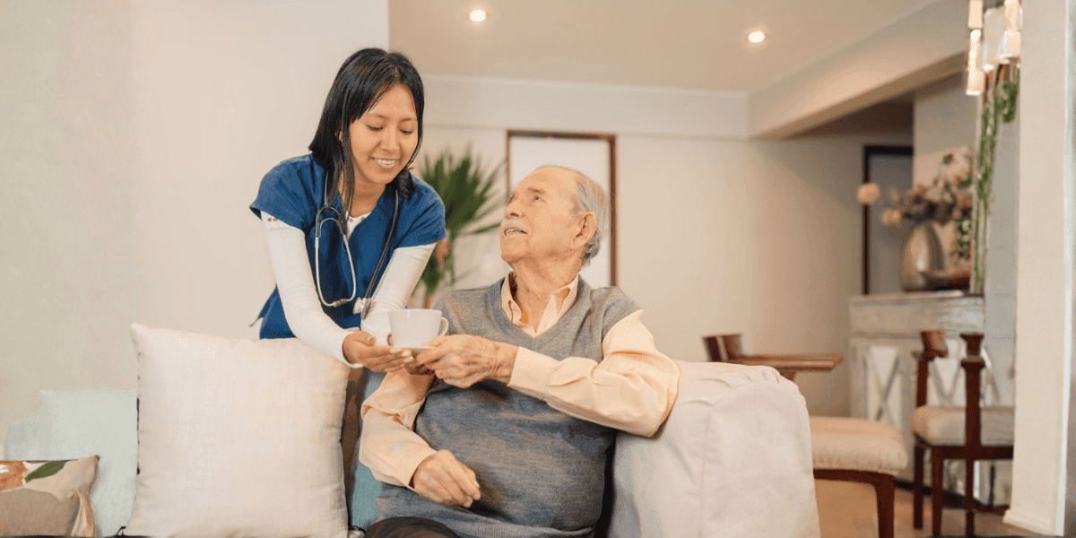 A caregiver providing home support to an elderly man, highlighting the importance of in-home care for memory loss management.