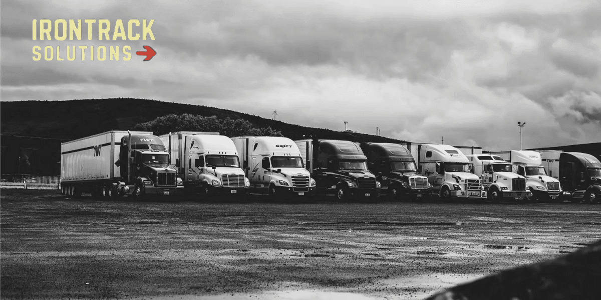Line of semi-trucks parked under cloudy skies, representing IronTrack's AI-driven fleet optimization and industrial performance solutions.