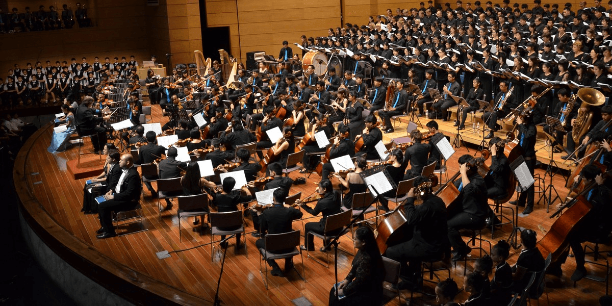 Siam Sinfonietta orchestra and choir performing onstage during a large symphonic concert.