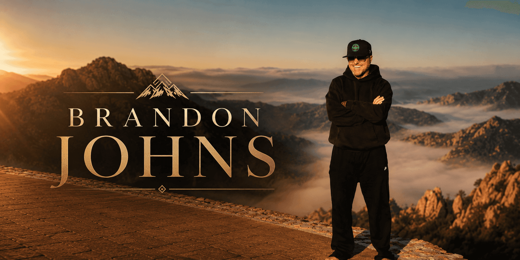 Brandon Johns standing on a mountain overlook at sunrise, promotional portrait for the Brandon from Georgia brand.
