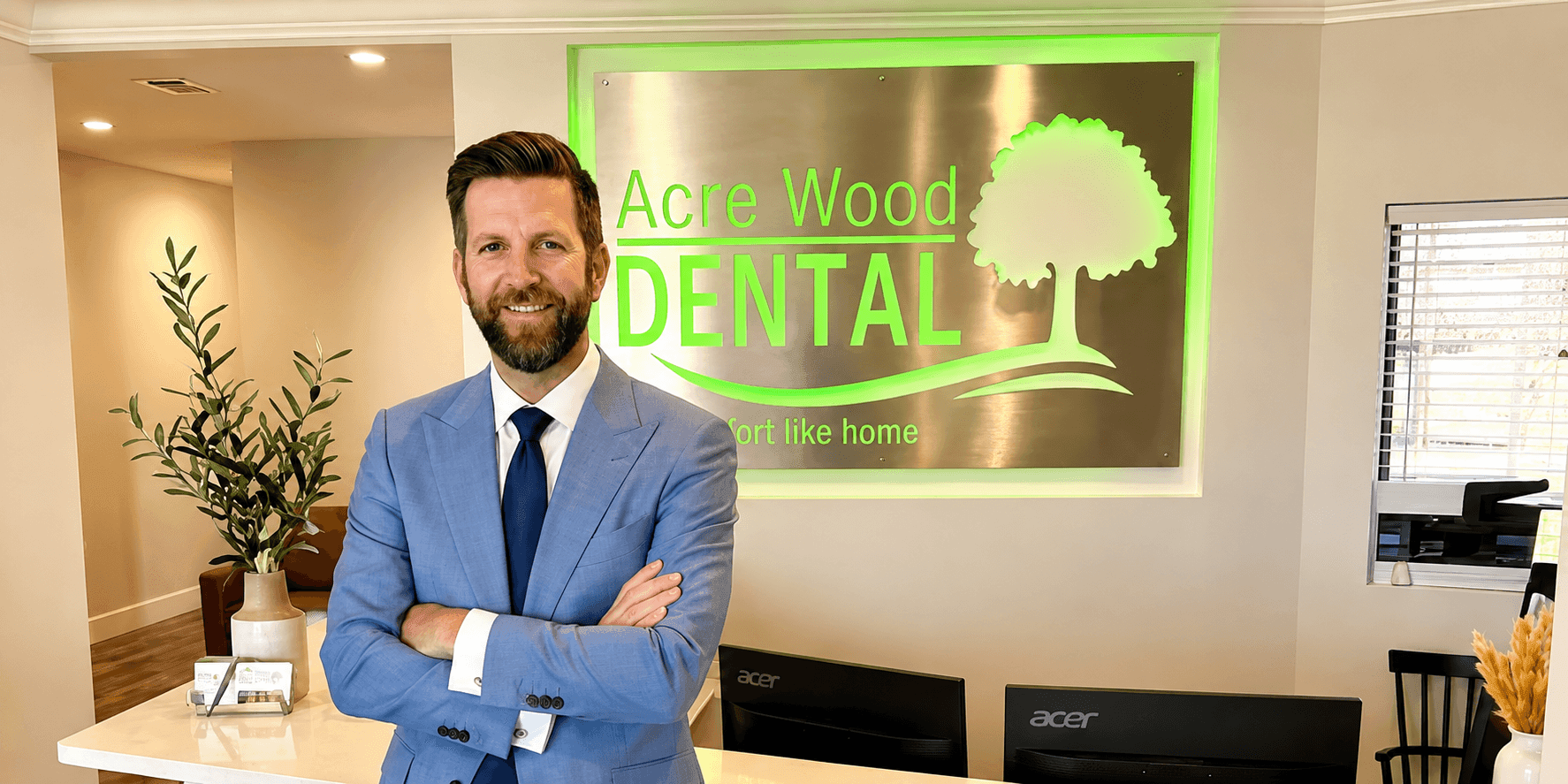 Dan Johnson standing in a blue suit inside Acre Wood Dental.