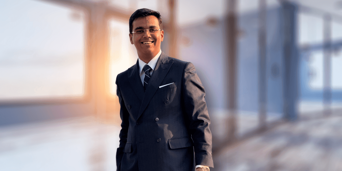 Professional man in a business suit, smiling confidently in a modern office setting with natural light.