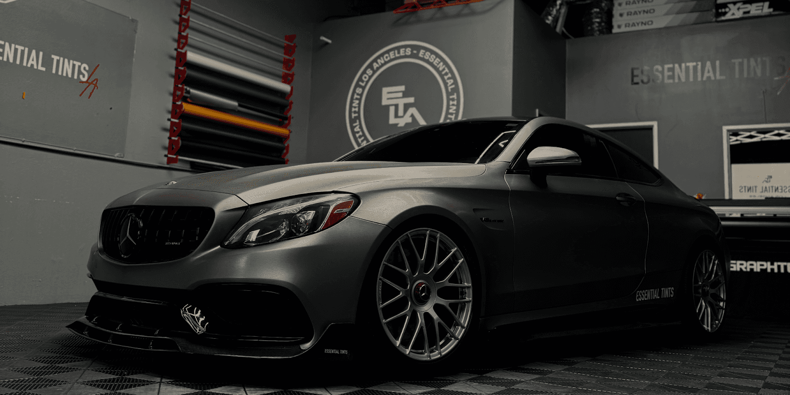 Matte-finished Mercedes-Benz coupe with custom wrap and Essential Tints logo, showcasing premium vehicle protection and aesthetics.