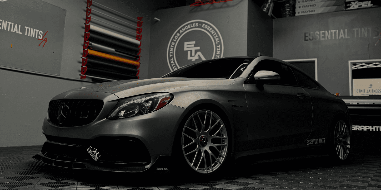 Matte-finished Mercedes-Benz coupe with custom wrap and Essential Tints logo, showcasing premium vehicle protection and aesthetics.
