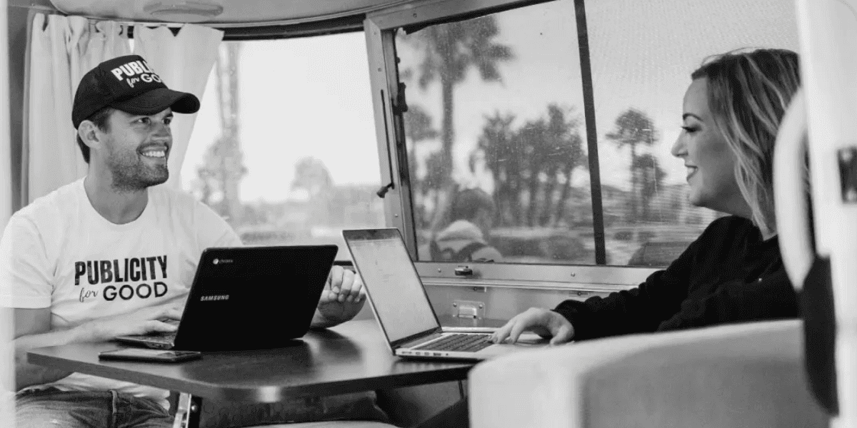 Two people working on laptops inside an Airstream, representing Publicity For Good’s purpose-driven PR initiative.