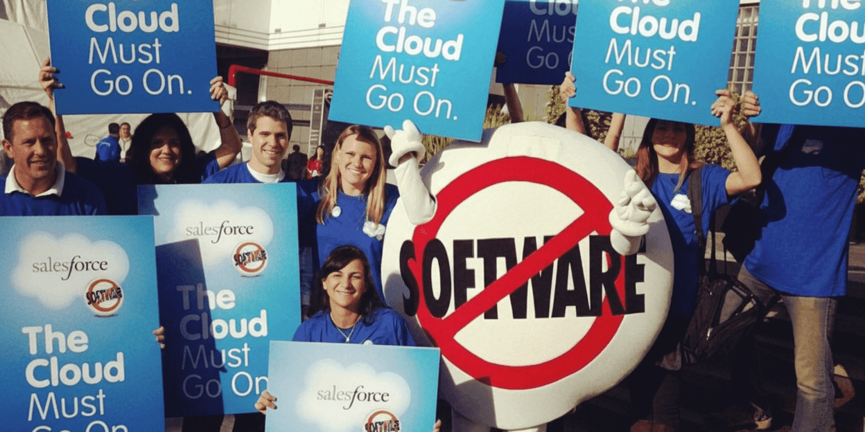 Protesters holding signs at a Salesforce event, referencing the company's original 'No Software' protest, mimicking its 2000 stunt.