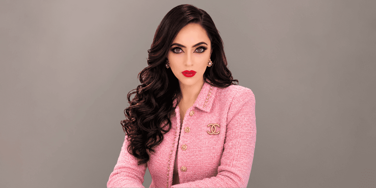 Professional portrait of hospitality entrepreneur Ashka Patel, CEO and hotel owner, in a pink blazer.