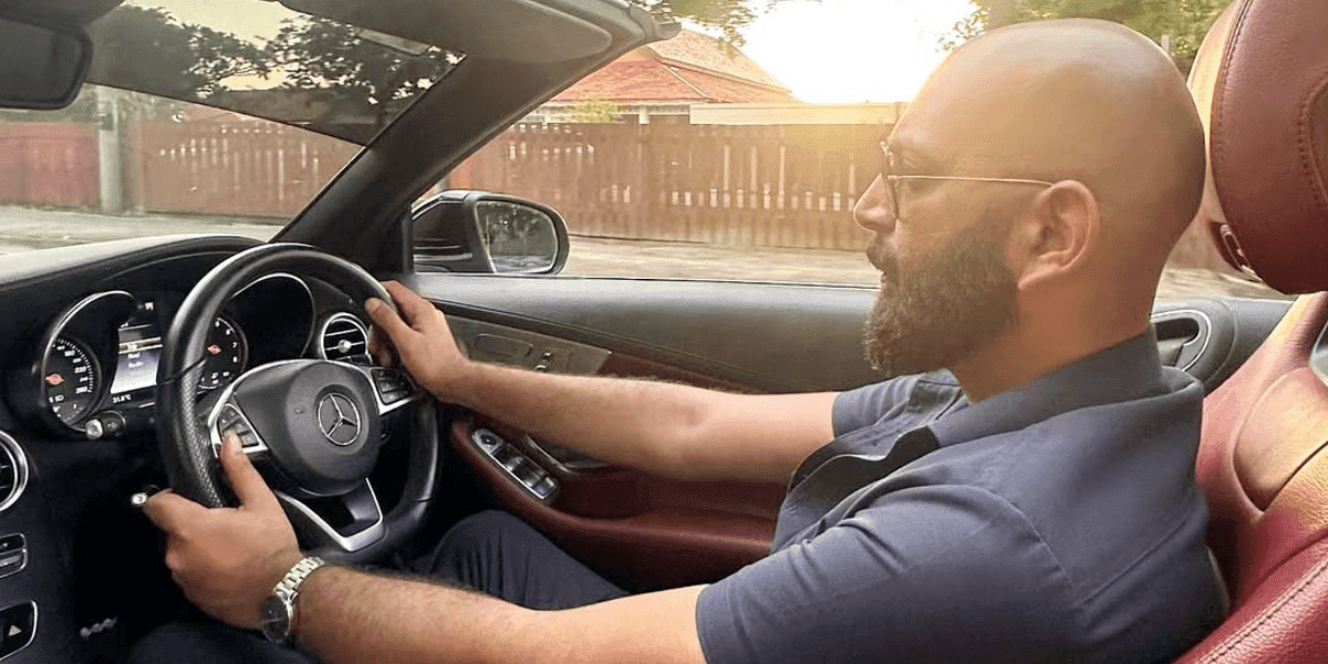 Ehtasham Malik driving a luxury car, representing his dynamic entrepreneurial lifestyle and success.