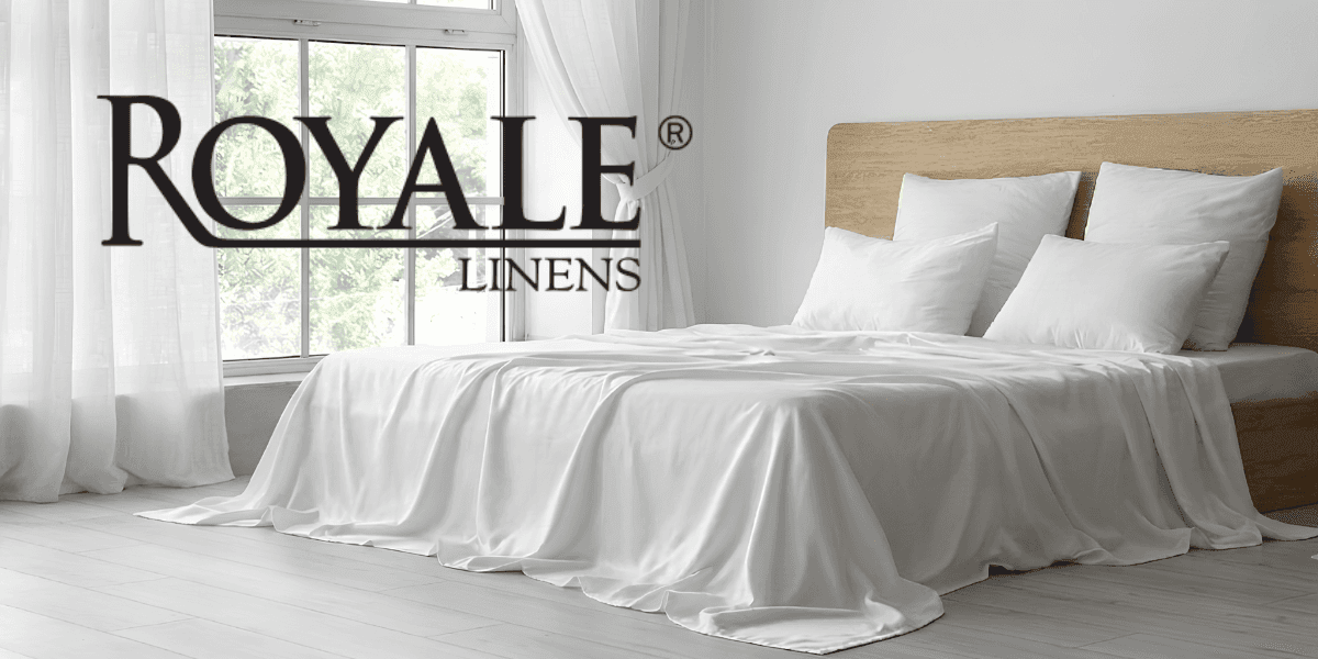 Royale Linens luxury cotton bedding displayed in a bright modern bedroom with soft white linens.