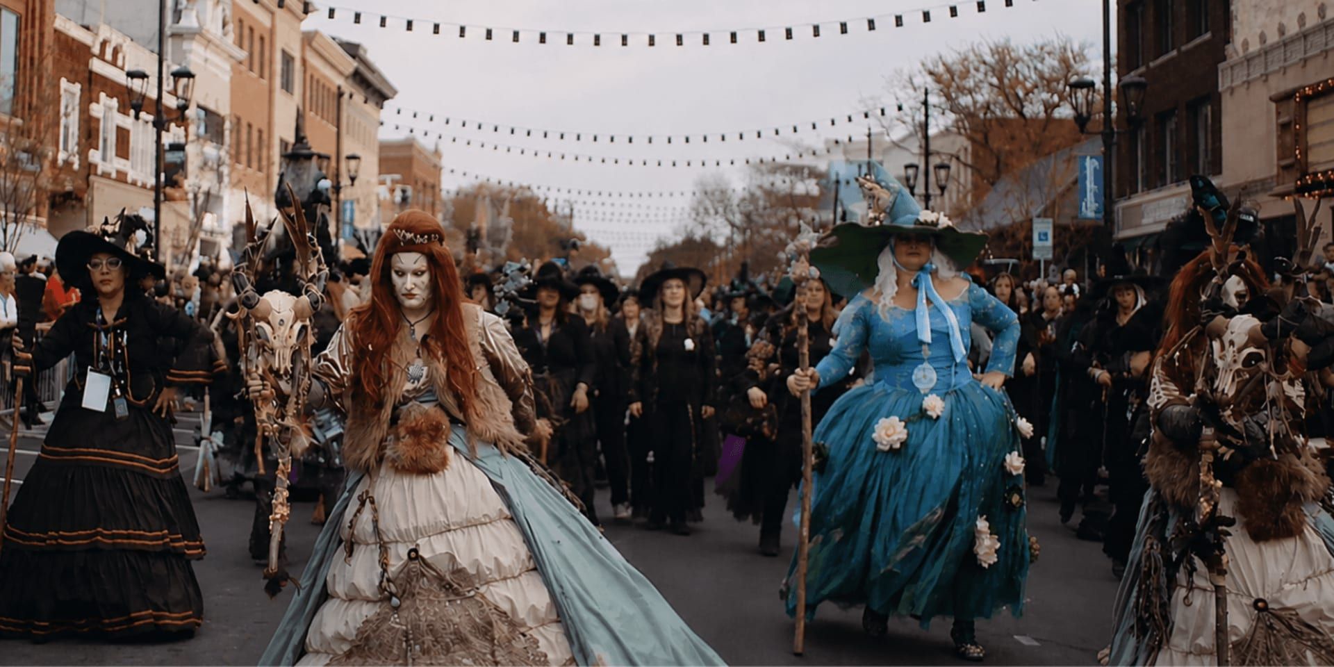 Elaborately costumed witches lead the Sandusky Witches Walk parade through downtown streets lined with spectators.