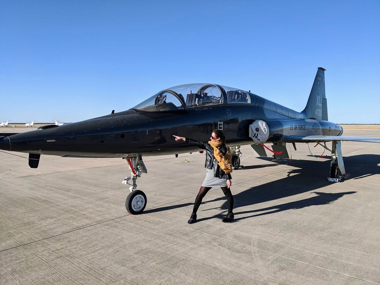 Rachel Beierle poses by a U.S. Air Force T-38 jet, representing The Mil Project’s mission to create vibrant communities for military families.