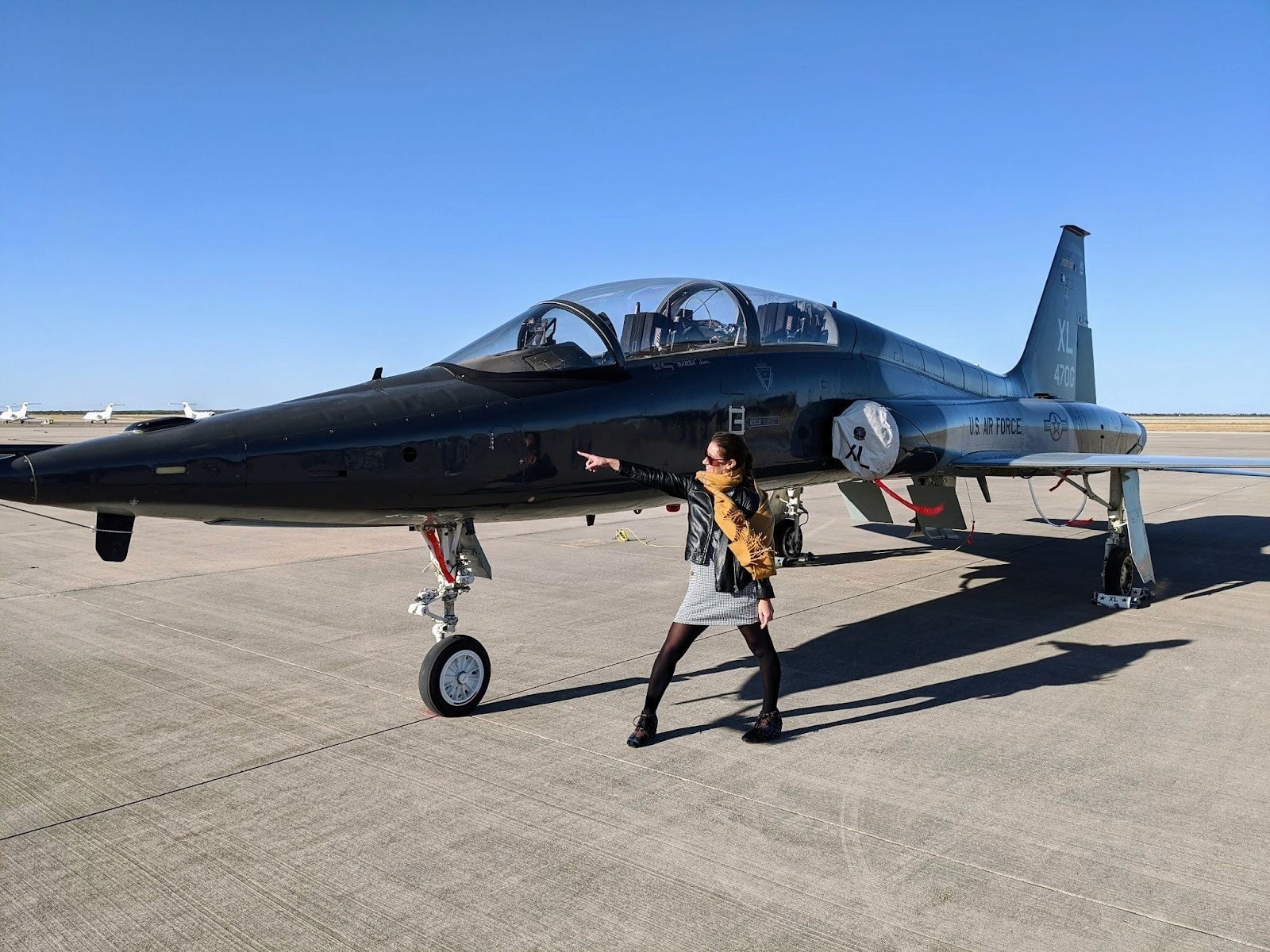 Rachel Beierle poses by a U.S. Air Force T-38 jet, representing The Mil Project’s mission to create vibrant communities for military families.