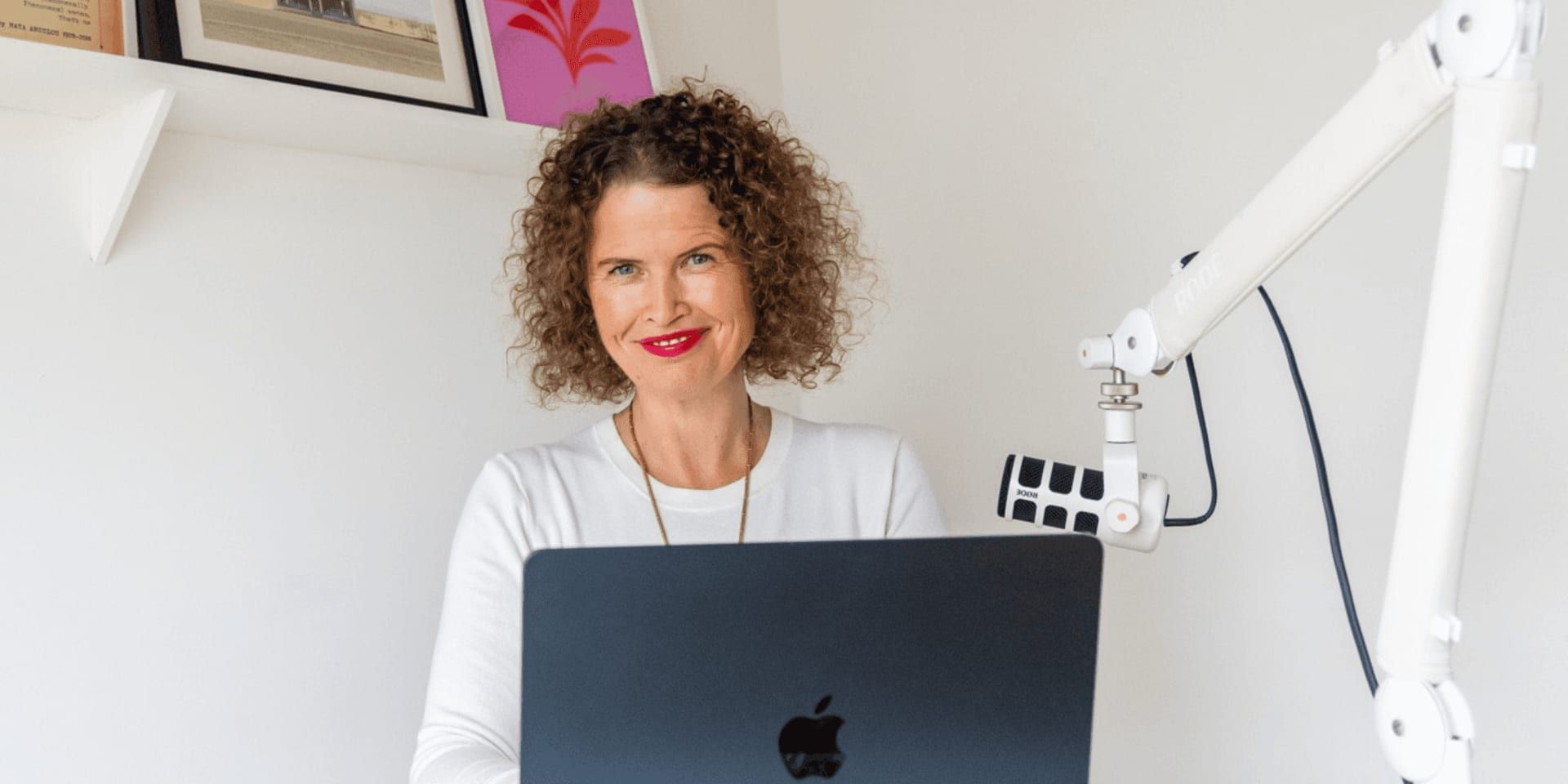 Dr Kate Armstrong at laptop beside podcast microphone, working from a bright home office.