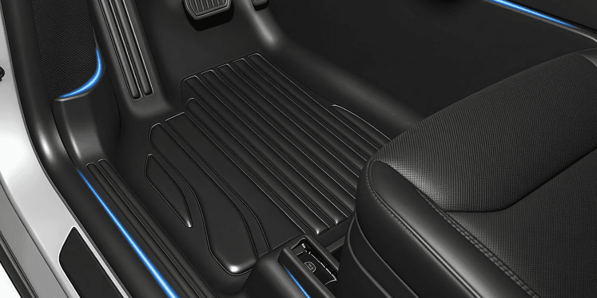 Tesla footwell with CabinProtect™ mats, precise fit, raised ridges, ambient blue lighting, offering full cabin protection and durability.