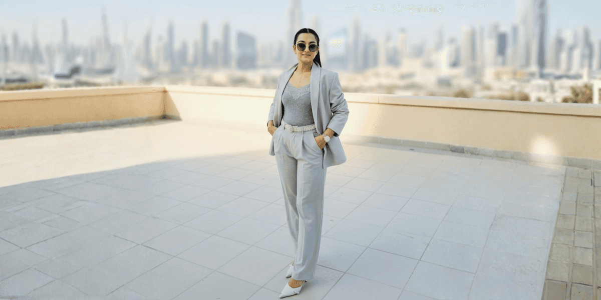 Prachi Dalal standing confidently in Dubai, wearing a stylish gray suit, offering expert guidance on off-plan real estate investments.